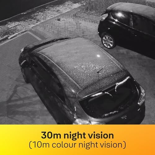 Cars parked in a lot captured by night vision camera.