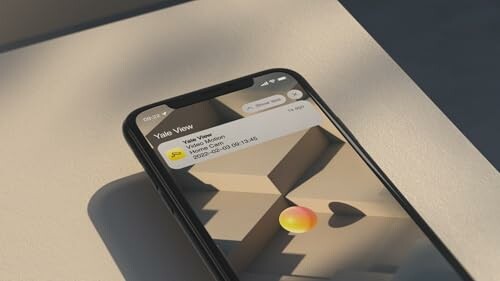 iPhone with notification on screen, shadow on table