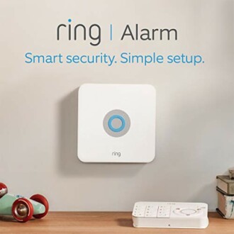Ring alarm system mounted on wall with keypad on table.